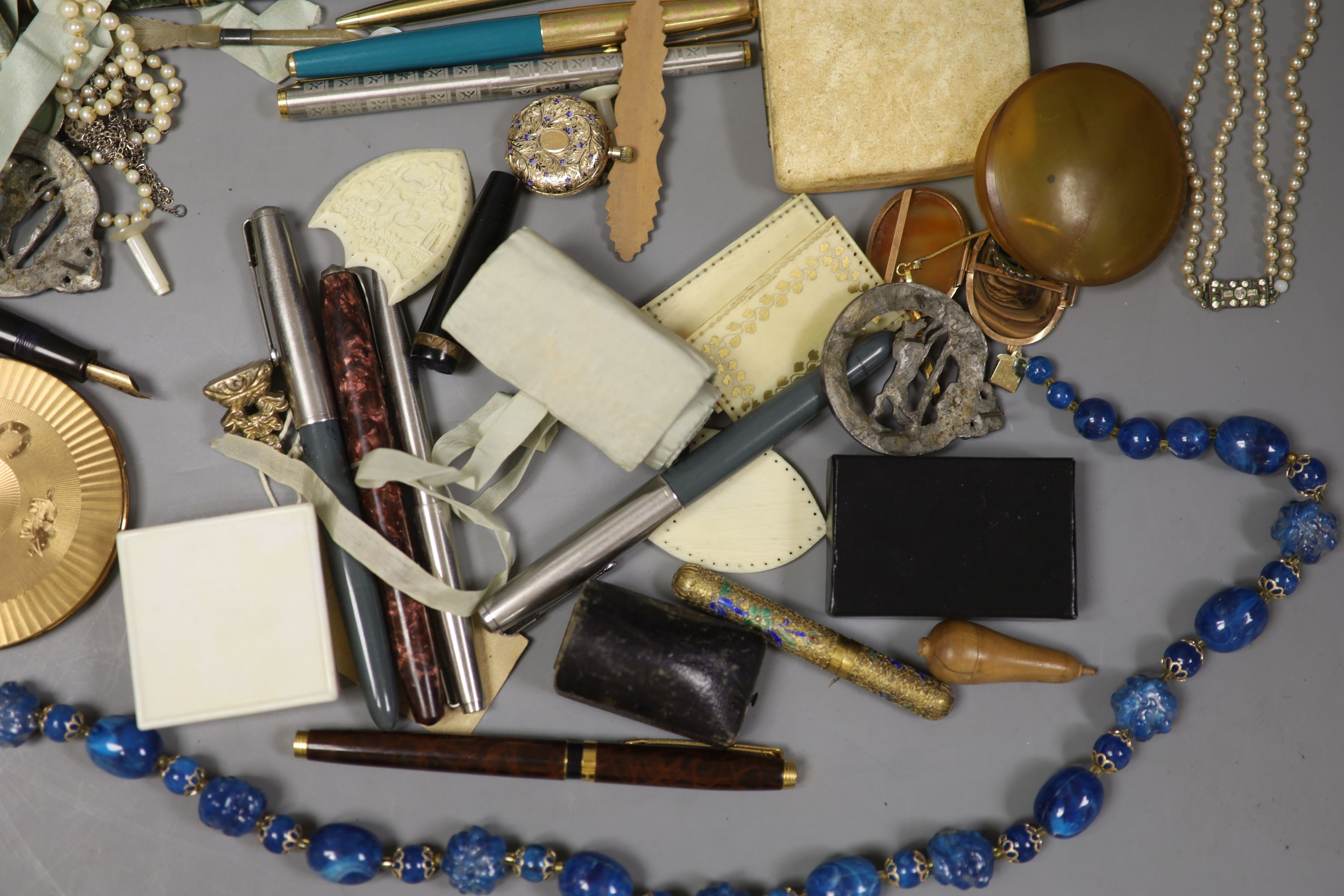 A mixed quantity of jewellery and collectables including 14lk fob watch, a cased set of three yellow metal dress studs, a 9ct opal and seed pearl brooch, a 9ct ring, Georg Jensen clip, costume jewellery, pens etc